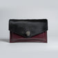 handmade burgundy leather bag with black cowhide and silver metal closure