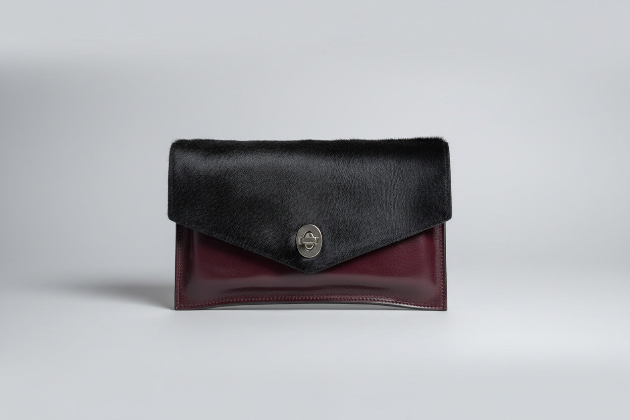 handmade burgundy leather bag with black cowhide and silver metal closure
