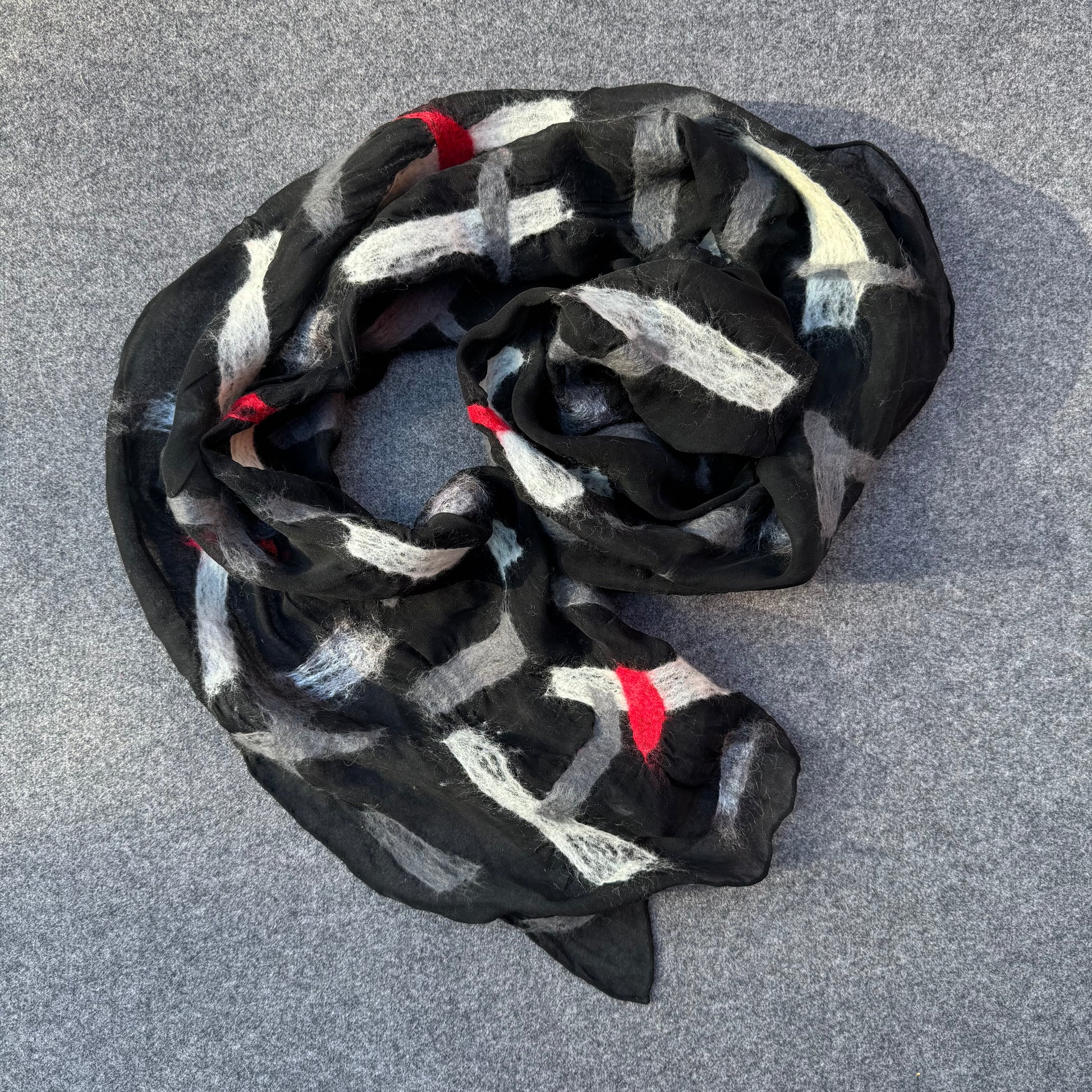Silk scarf with black, white, and red pattern in merino wool