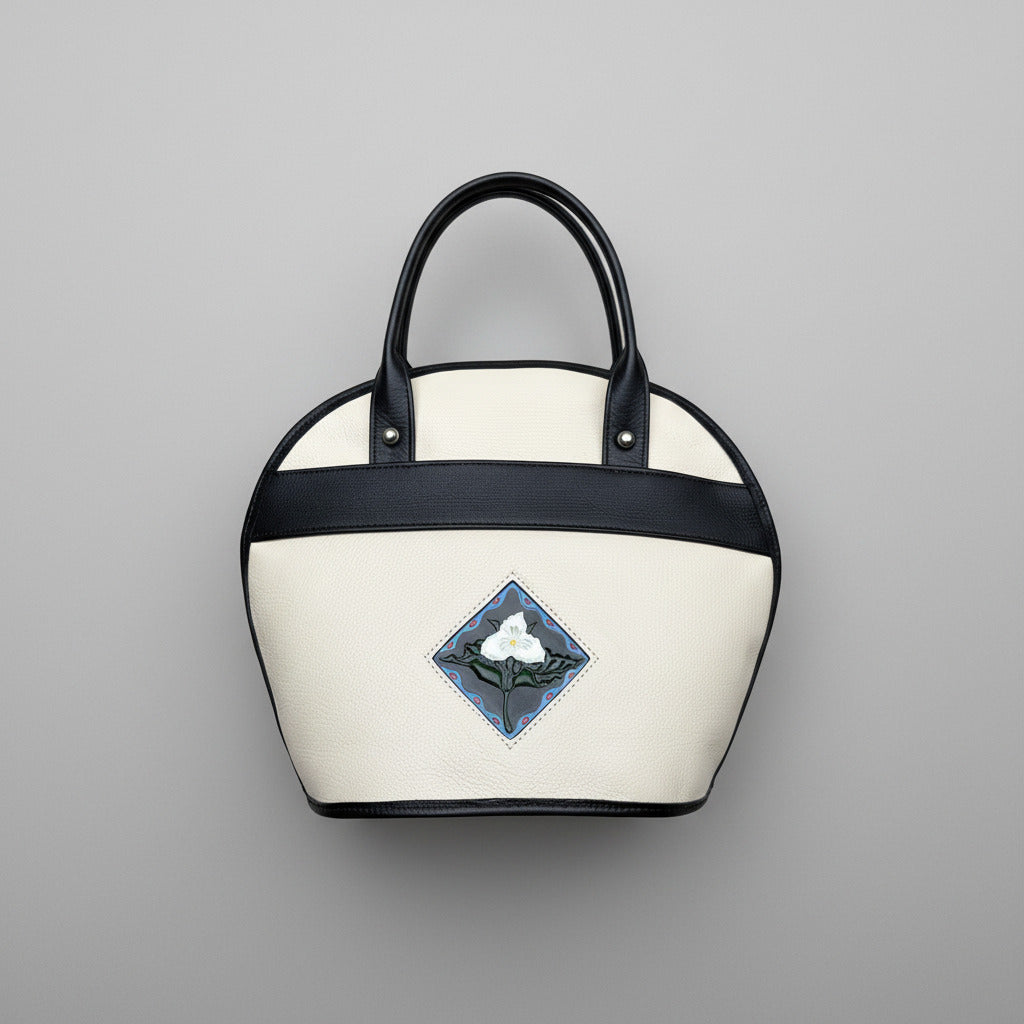 White handbag with black handle and trillium embossed design and handpainted on on leather