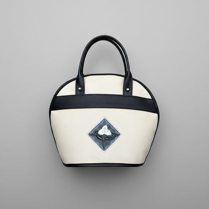 White handbag with black handle and trillium embossed design and handpainted on on leather