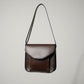 A brown leather crossbody bag with an adjustable strap, handmade in Door County, WI